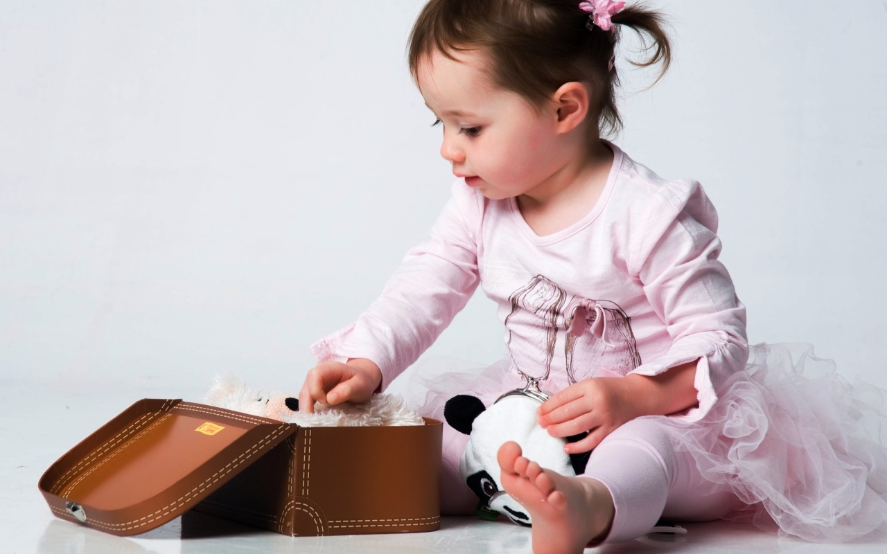 Девочка в розовом наряде с маленьким чемоданом