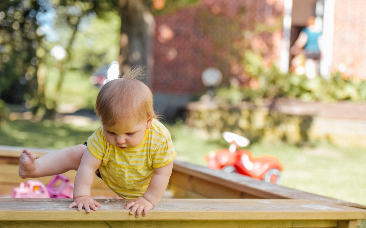 Маленький мальчик играет в песочнице