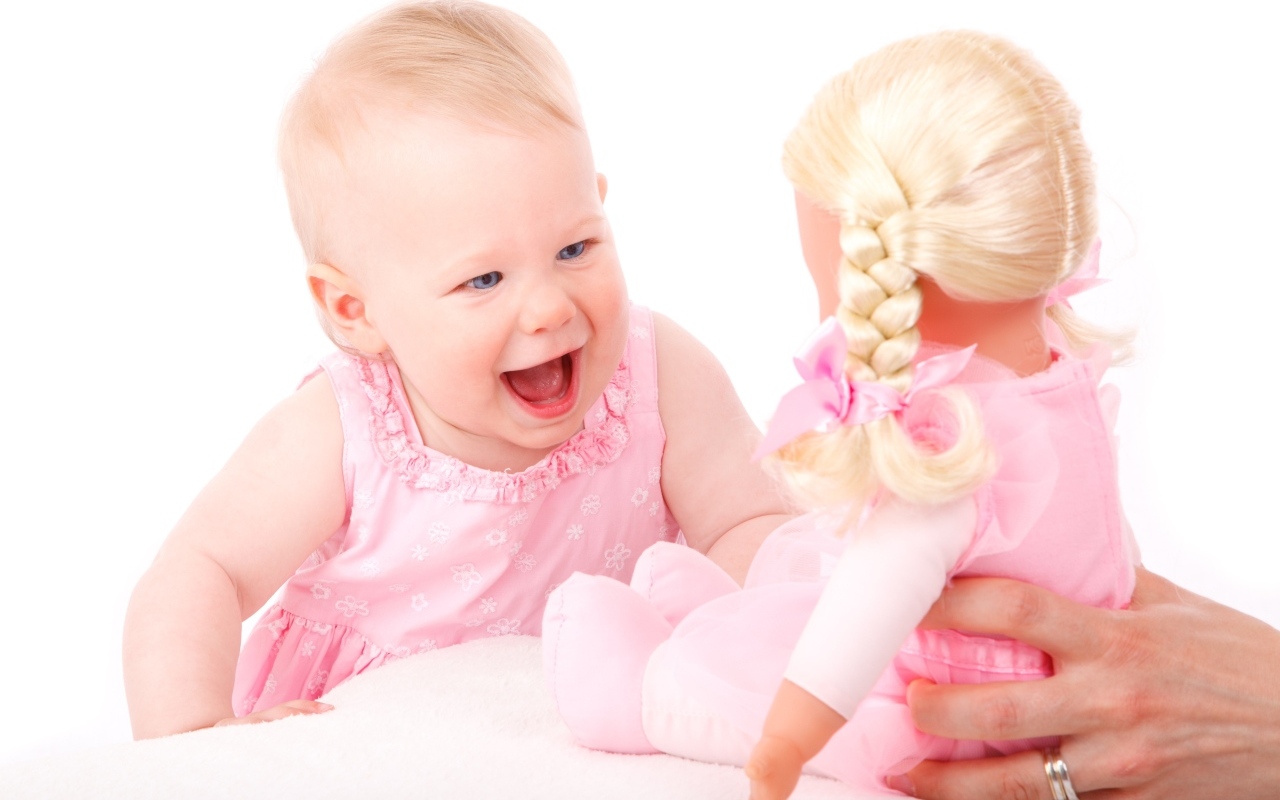 Маленькая улыбающаяся девочка с куклой