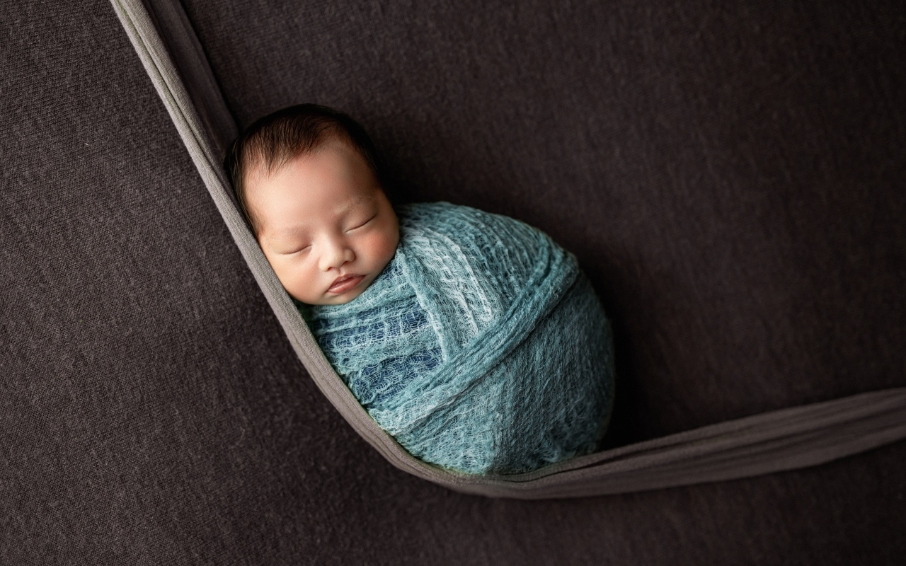 Маленький спящий ребенок завернут в покрывало