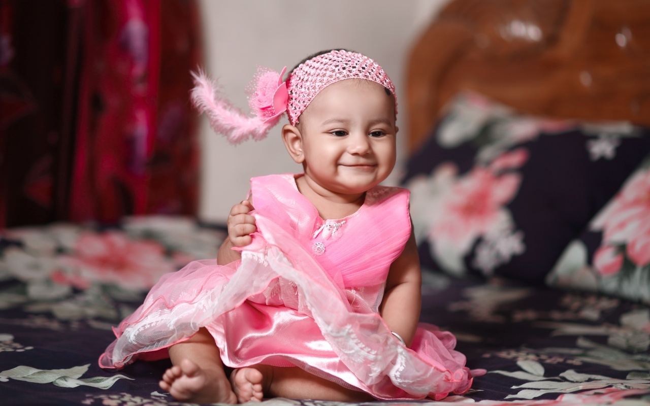 Улыбающаяся девочка в красивом розовом платье