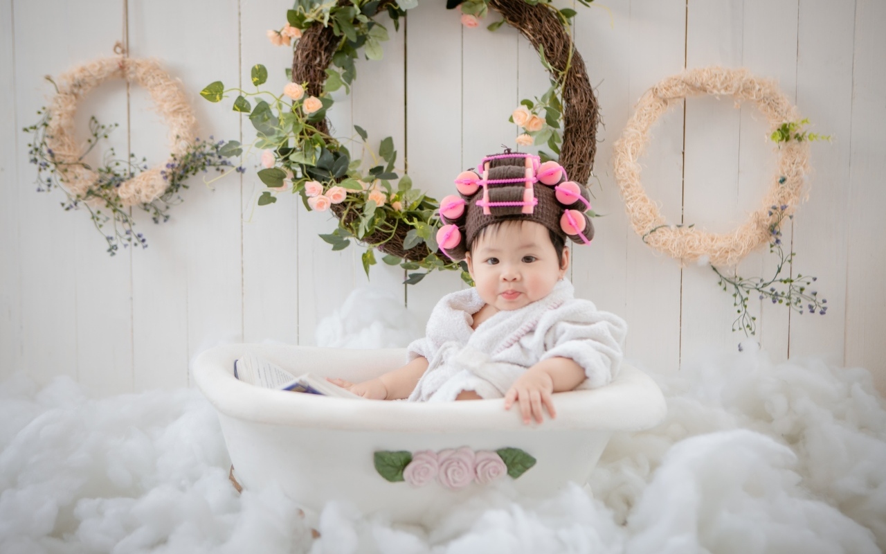 Ребенок сидит в ванной в халате