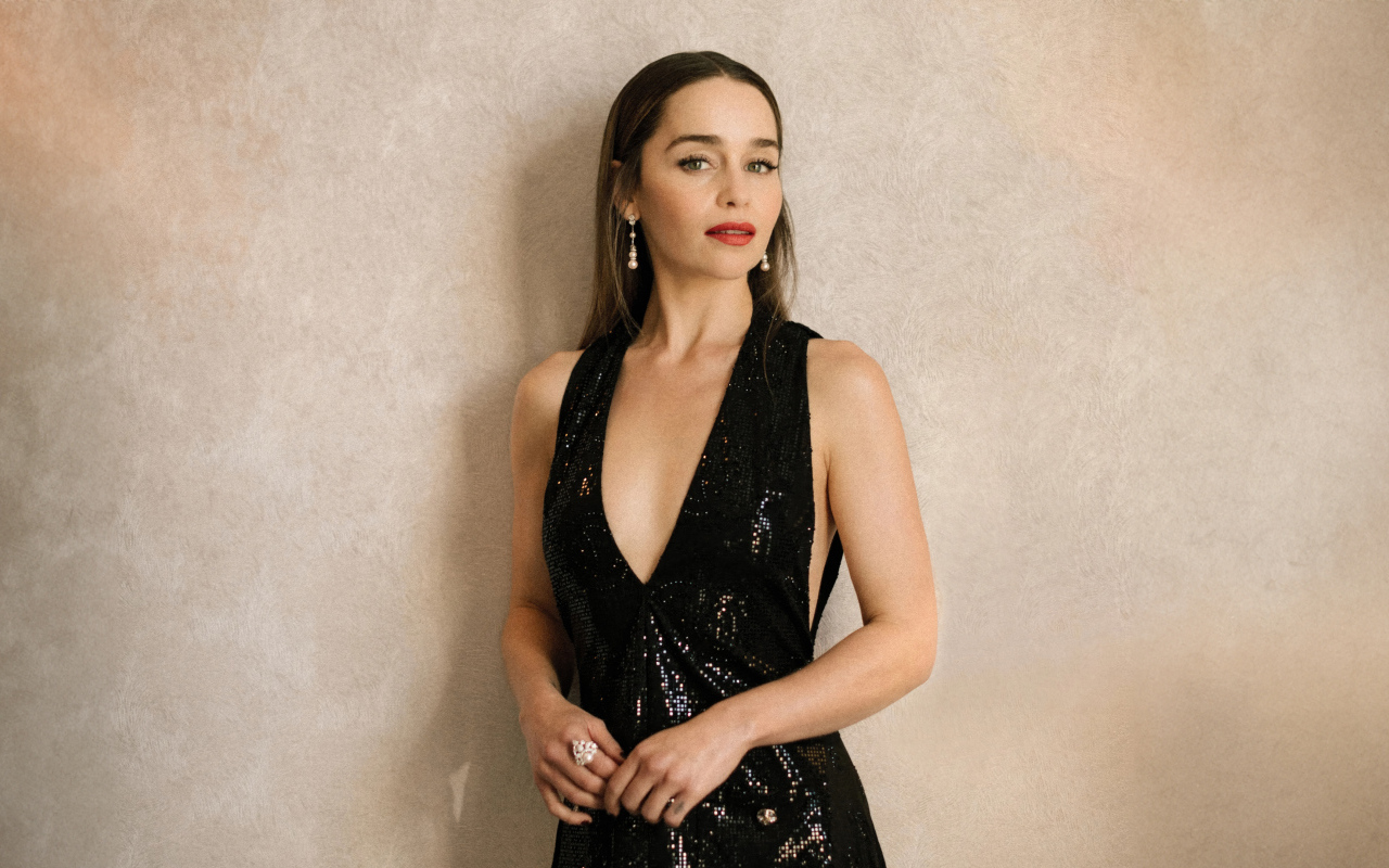 Популярная молодая актриса Эмилия Кларк в черном платье у стены