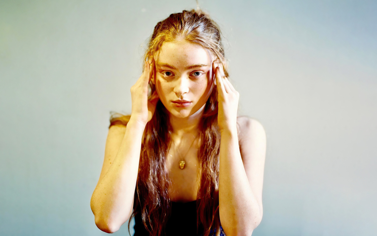 Рыжеволосая американская актриса Сэди Синк на сером фоне