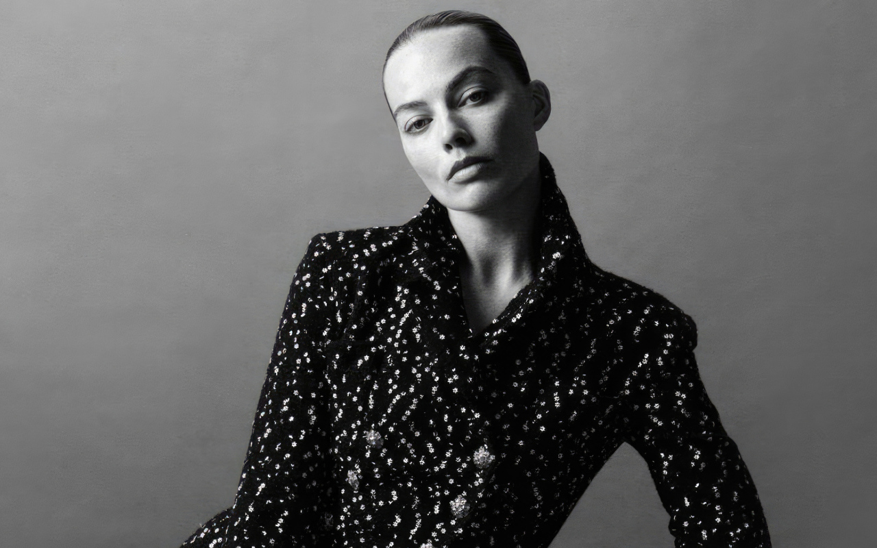 Грустная Марго Робби в блестящем пиджаке на сером фоне