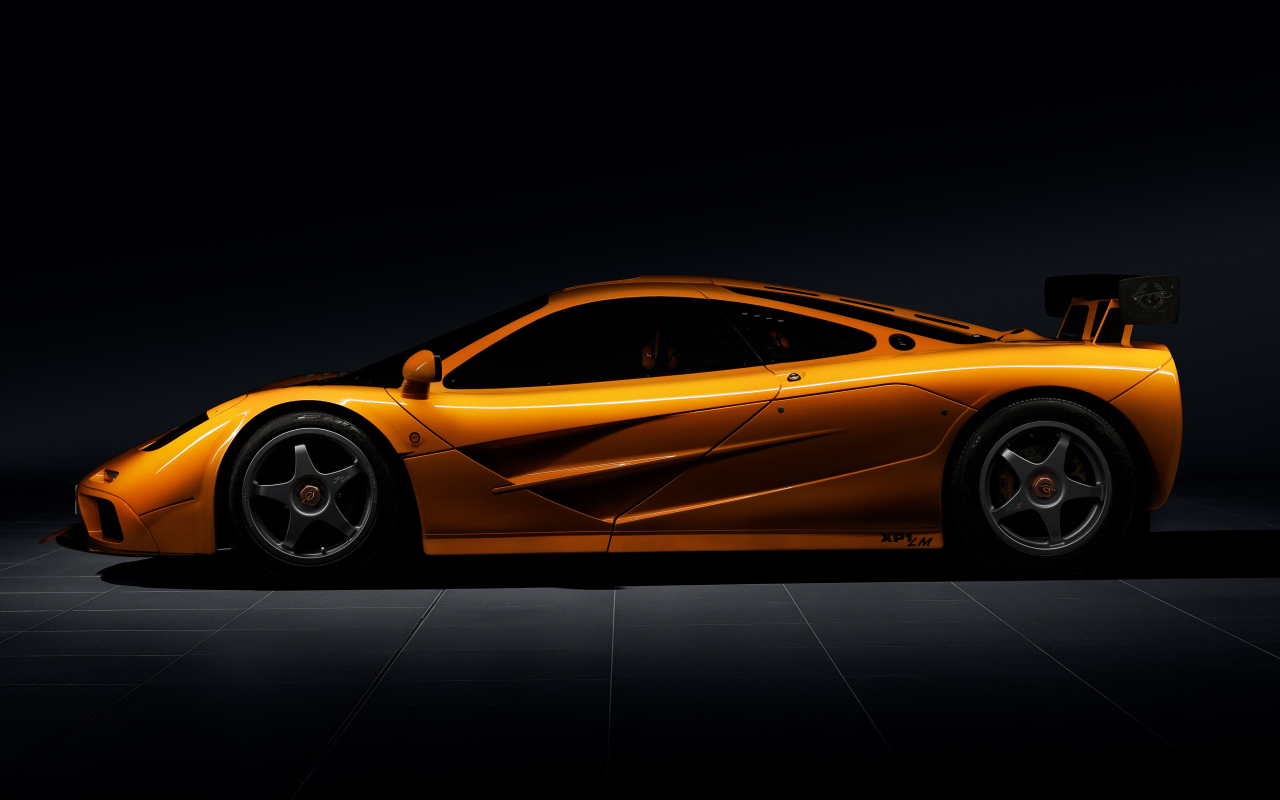 Вид сбоку на оранжевый автомобиль  McLaren F1 LM