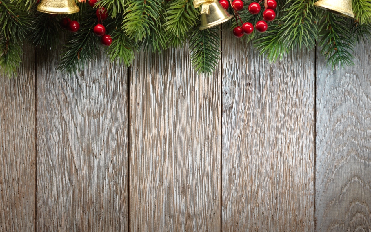 Деревянный новогодний фон с еловой веткой и колокольчиками