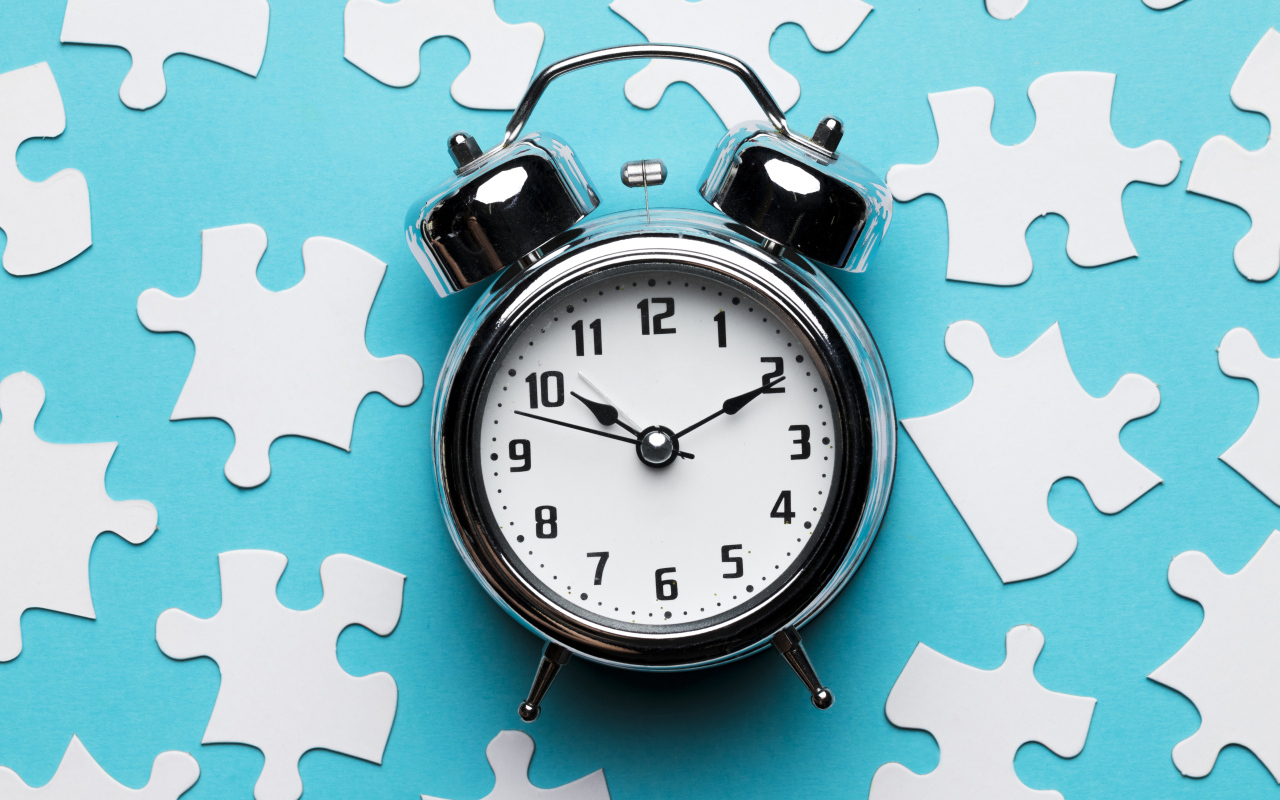 Будильник на голубом фоне с пазлами