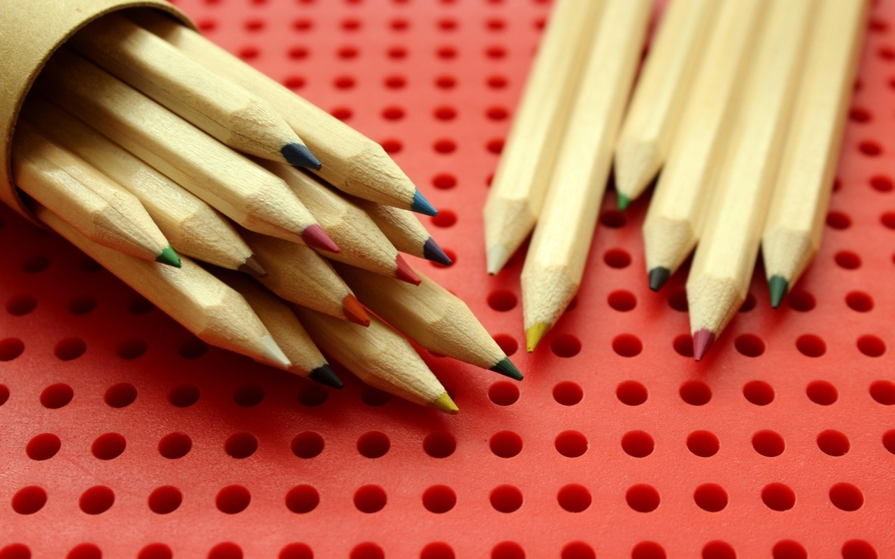 Заточенные карандаши на красном фоне