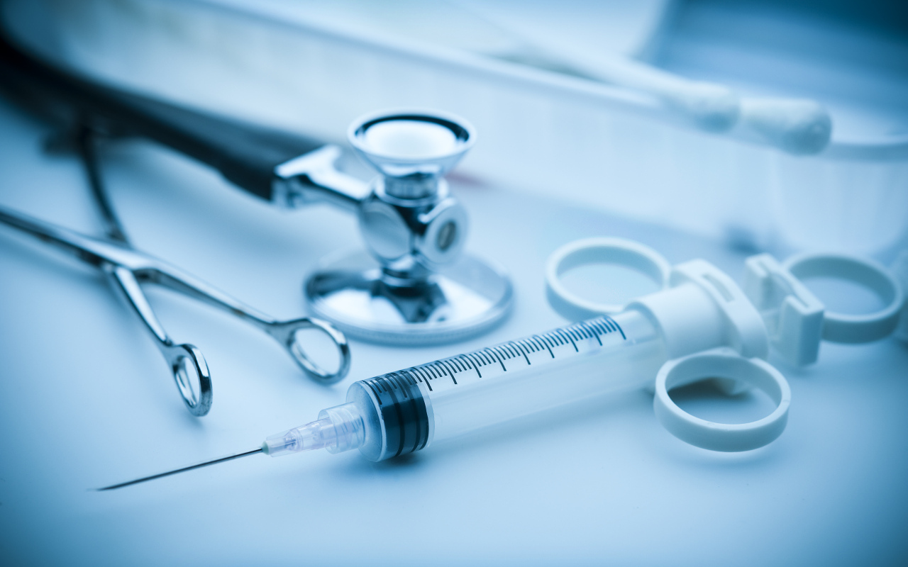 Шприц, зажим  и стетоскоп на столе