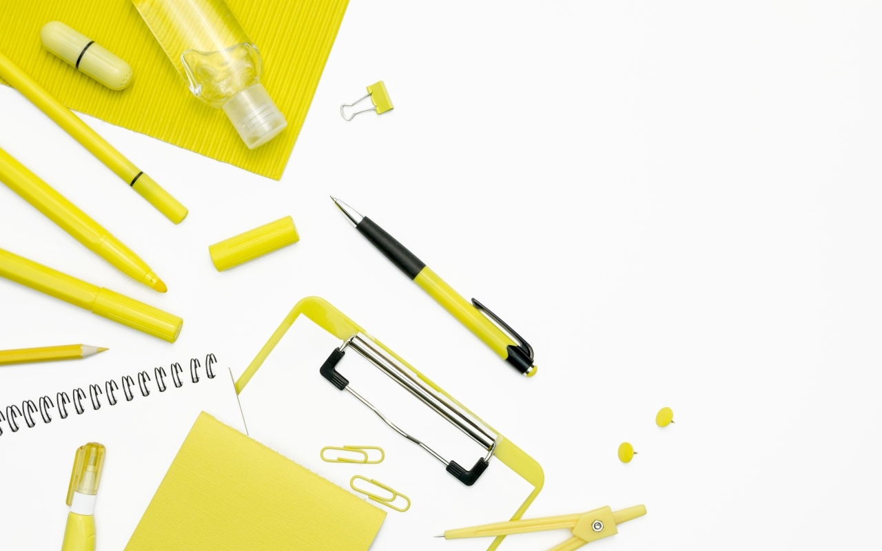 Желтые канцелярские предметы на белом фоне