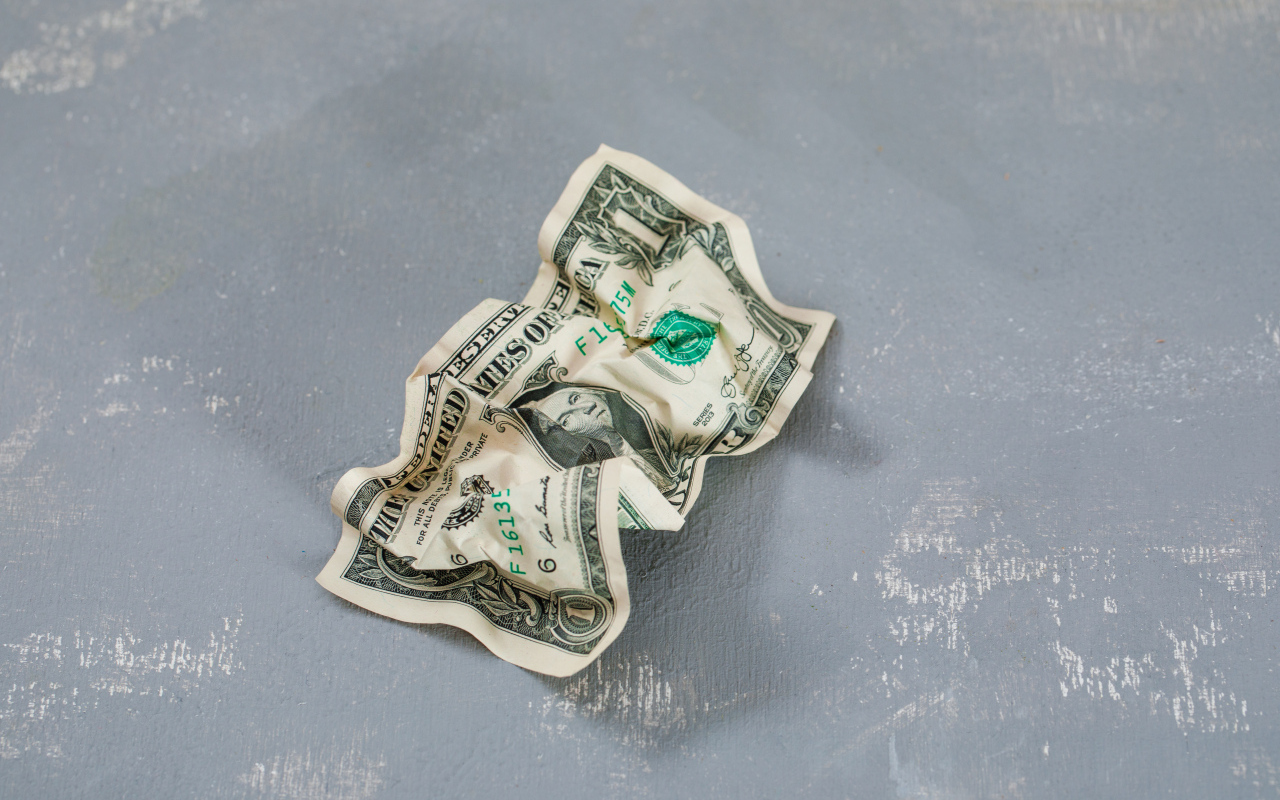 Смятая купюра один доллар на сером столе