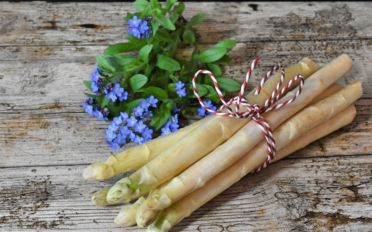 Спаржа на столе с цветами незабудки