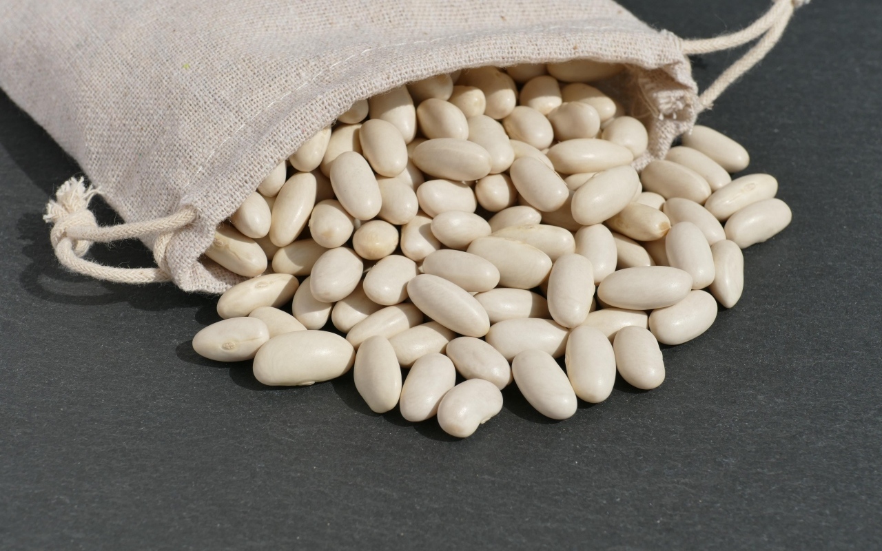 Фасоль в мешочке на сером столе