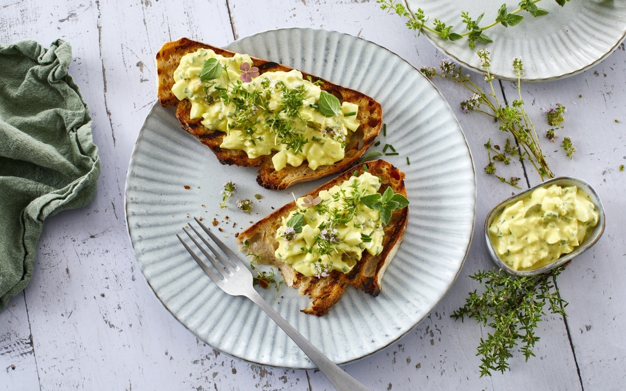 Гренки с кремом и зеленью на тарелке