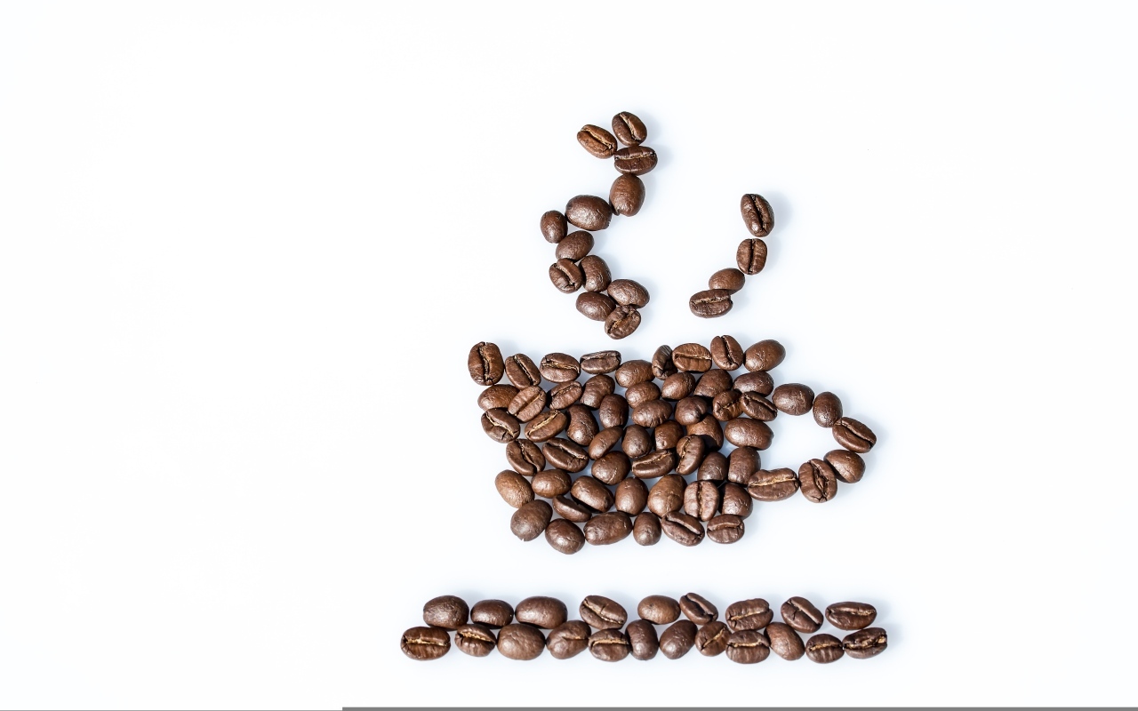 Чашка из кофейных зерен на белом столе