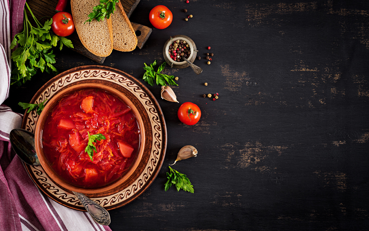 Вкусный красный борщ в тарелке на столе