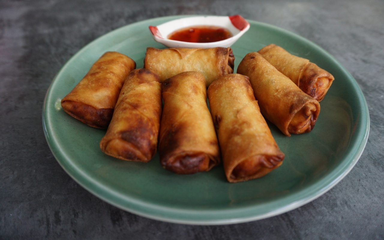 Яичные рулетики на большой тарелке с соусом