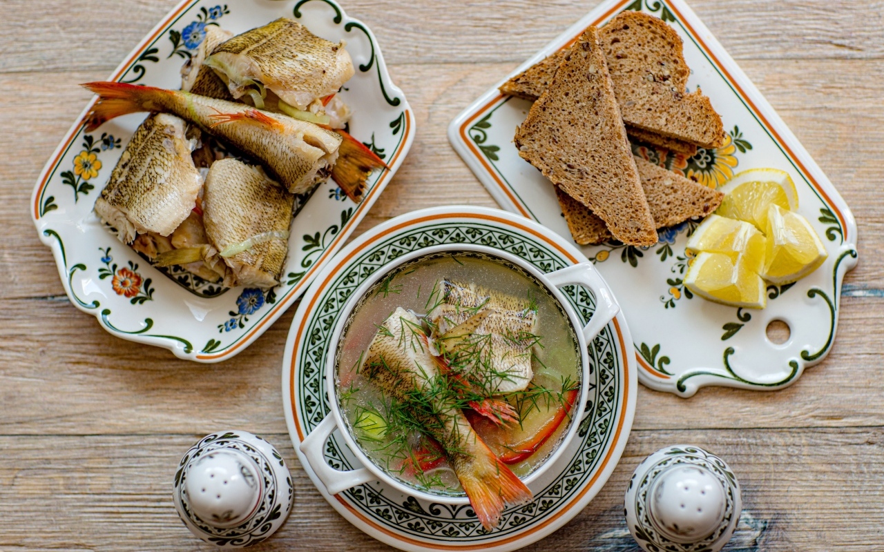 Уха на столе с хлебом и лимоном