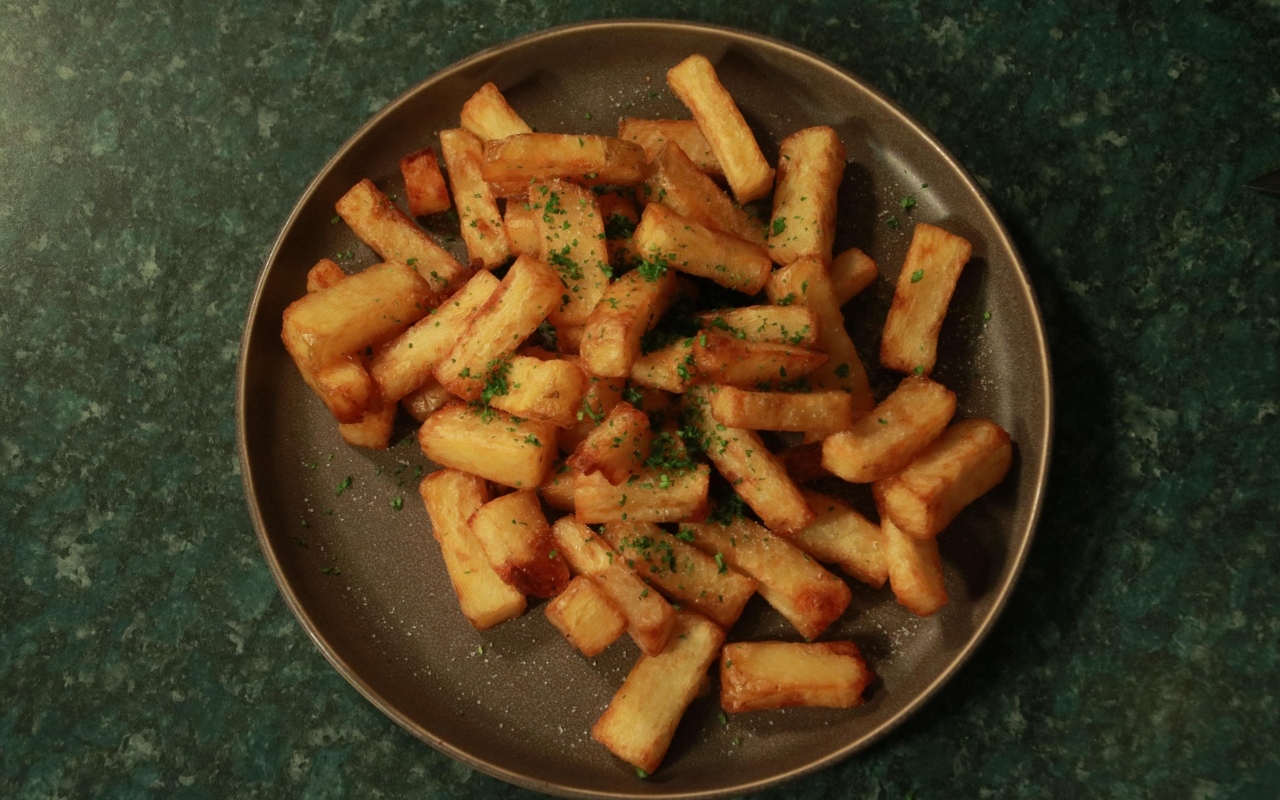 Картофель фри на большой тарелке на столе