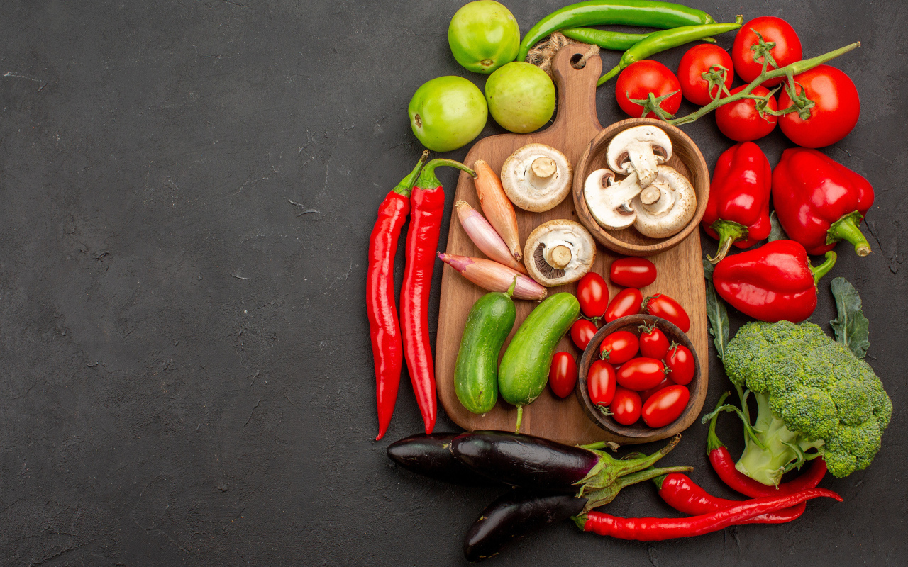 Свежие овощи на разделочной доске на столе