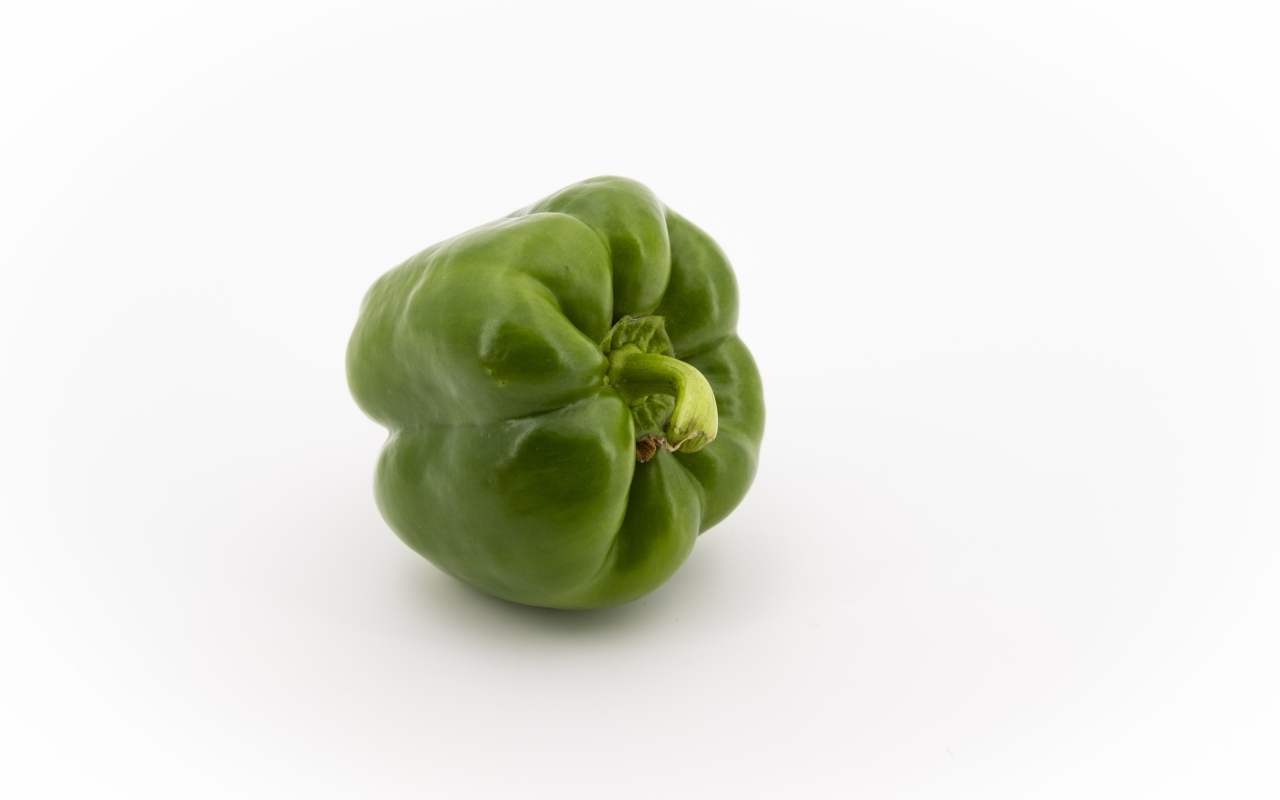 Зеленая паприка на белом фоне