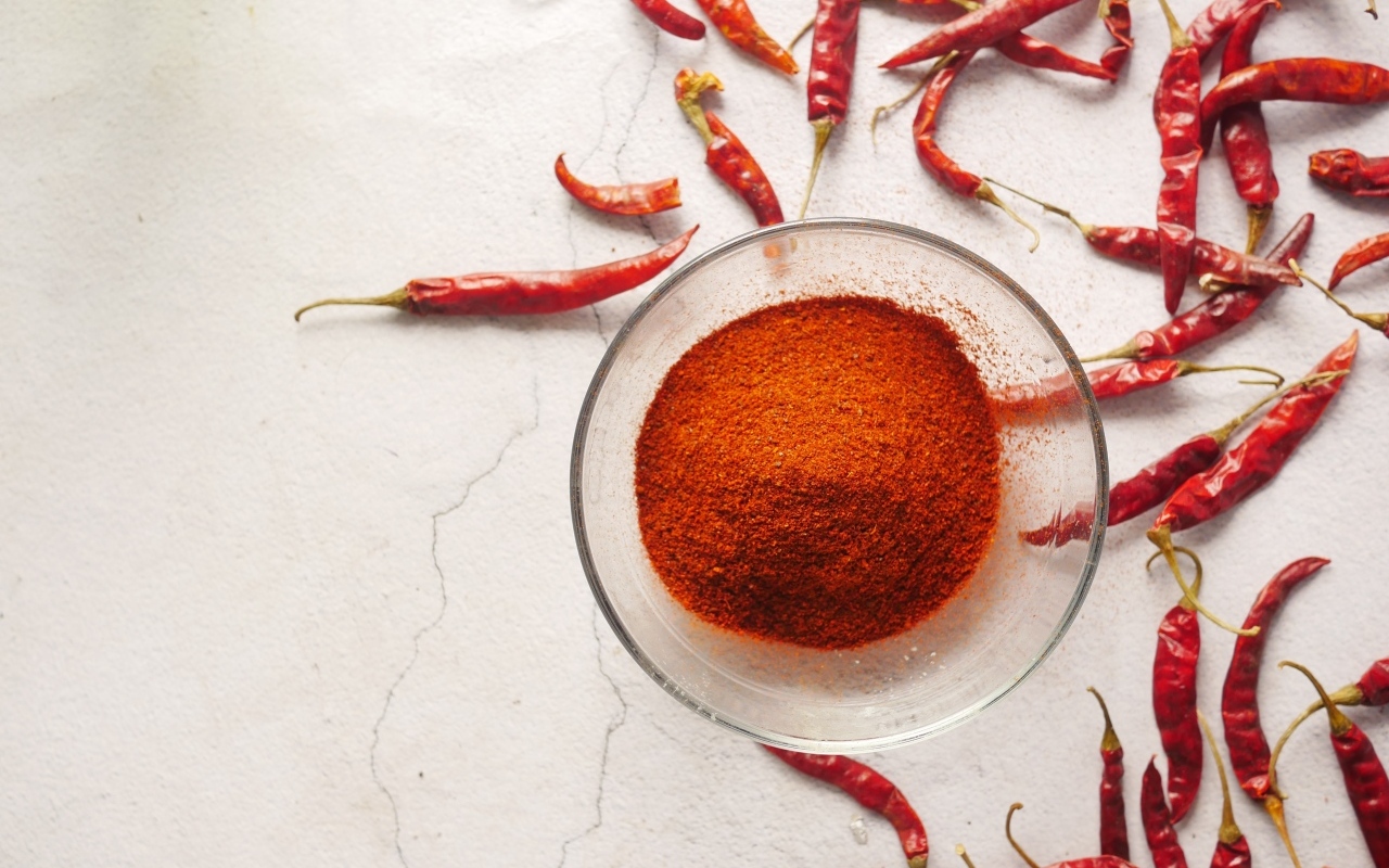 Молотый жгучий красный перец на столе