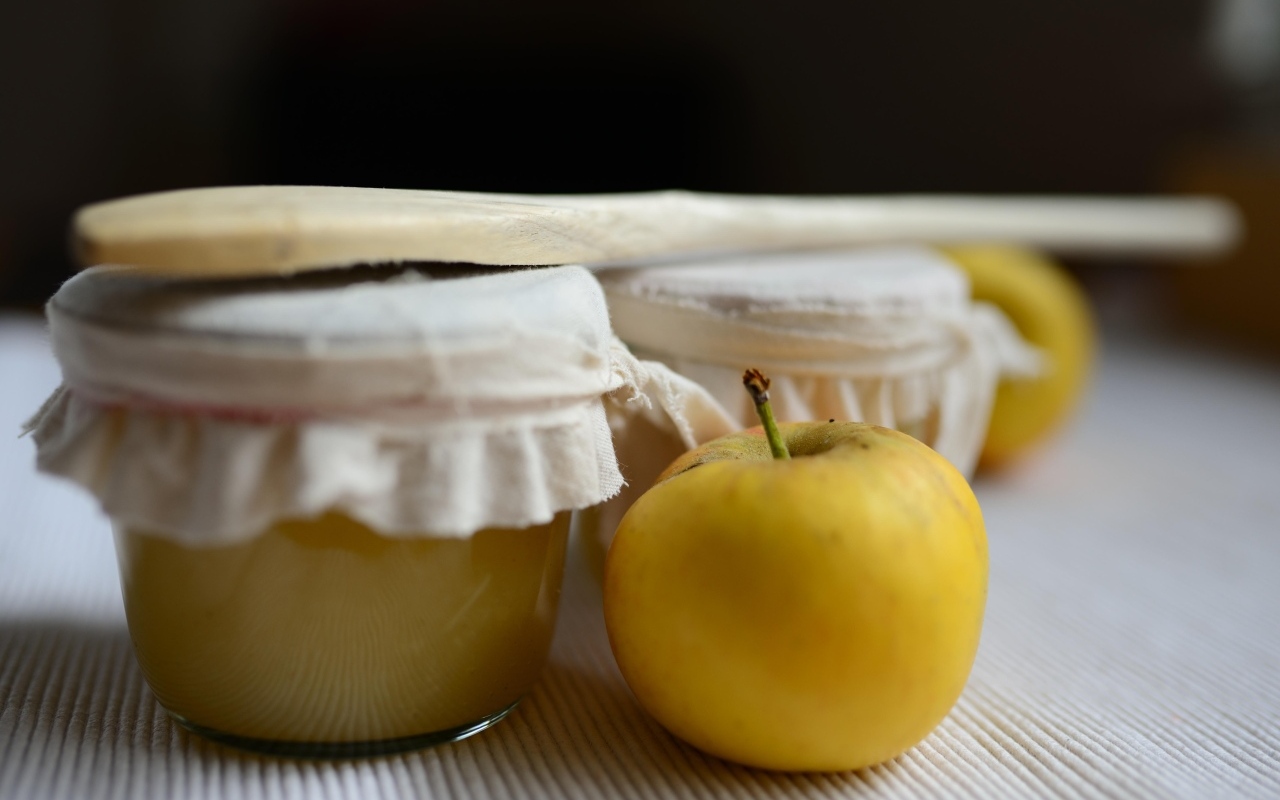 Яблочное пюре в банке на столе с плодами