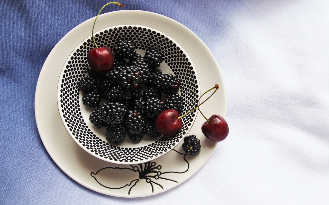 Ягоды ежевики и черешни на столе