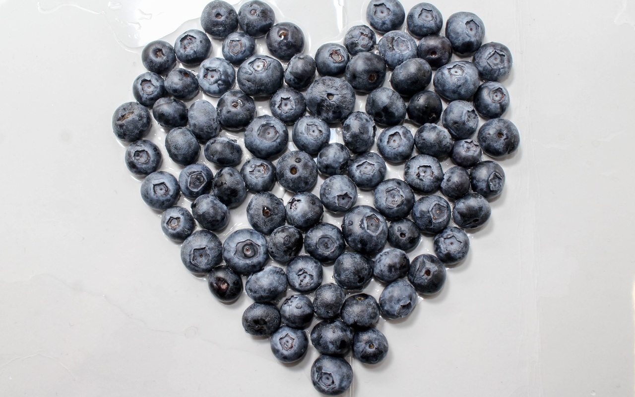 Сердце из ягод черники на сером столе