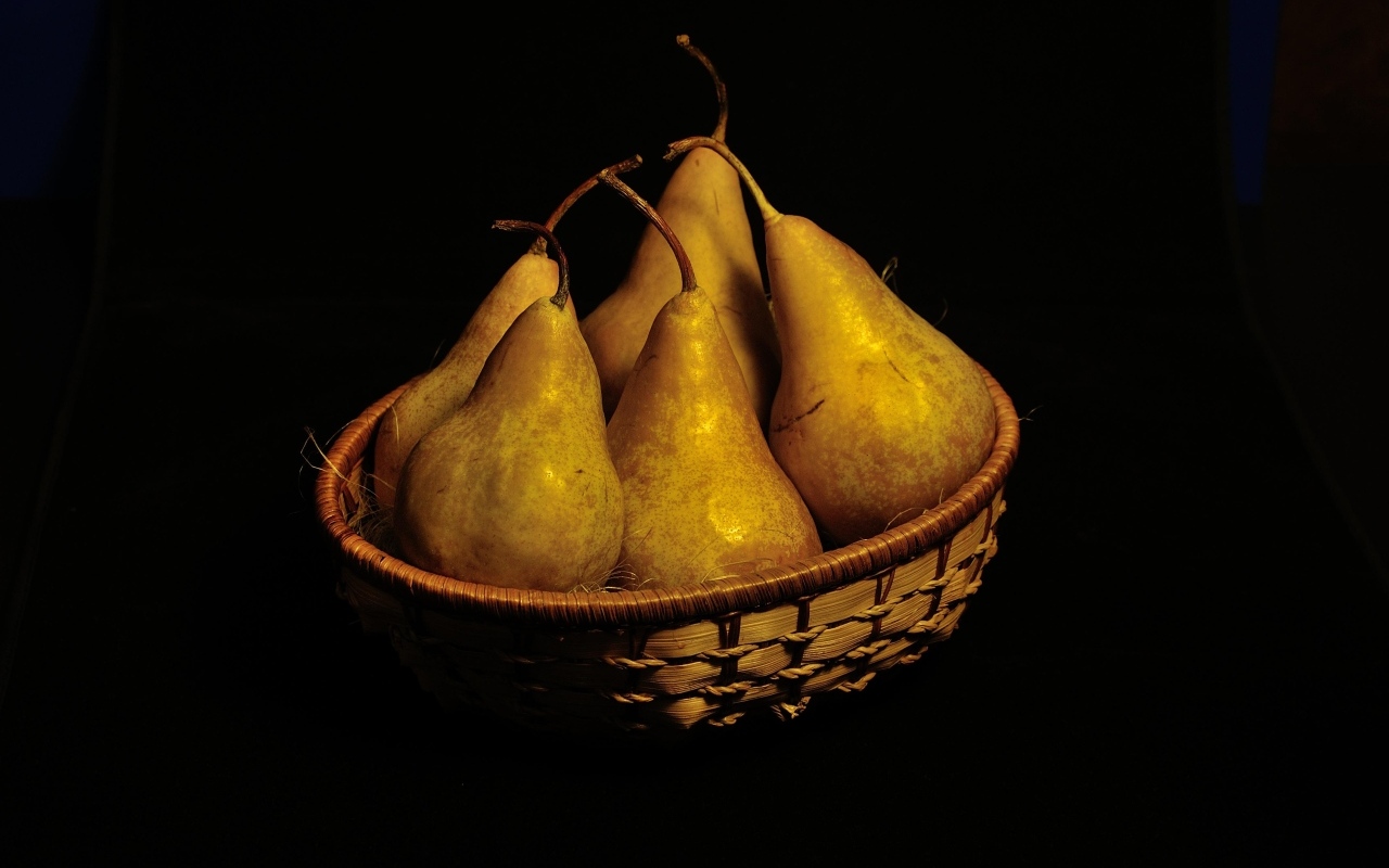 Груши в корзинке на черном фоне