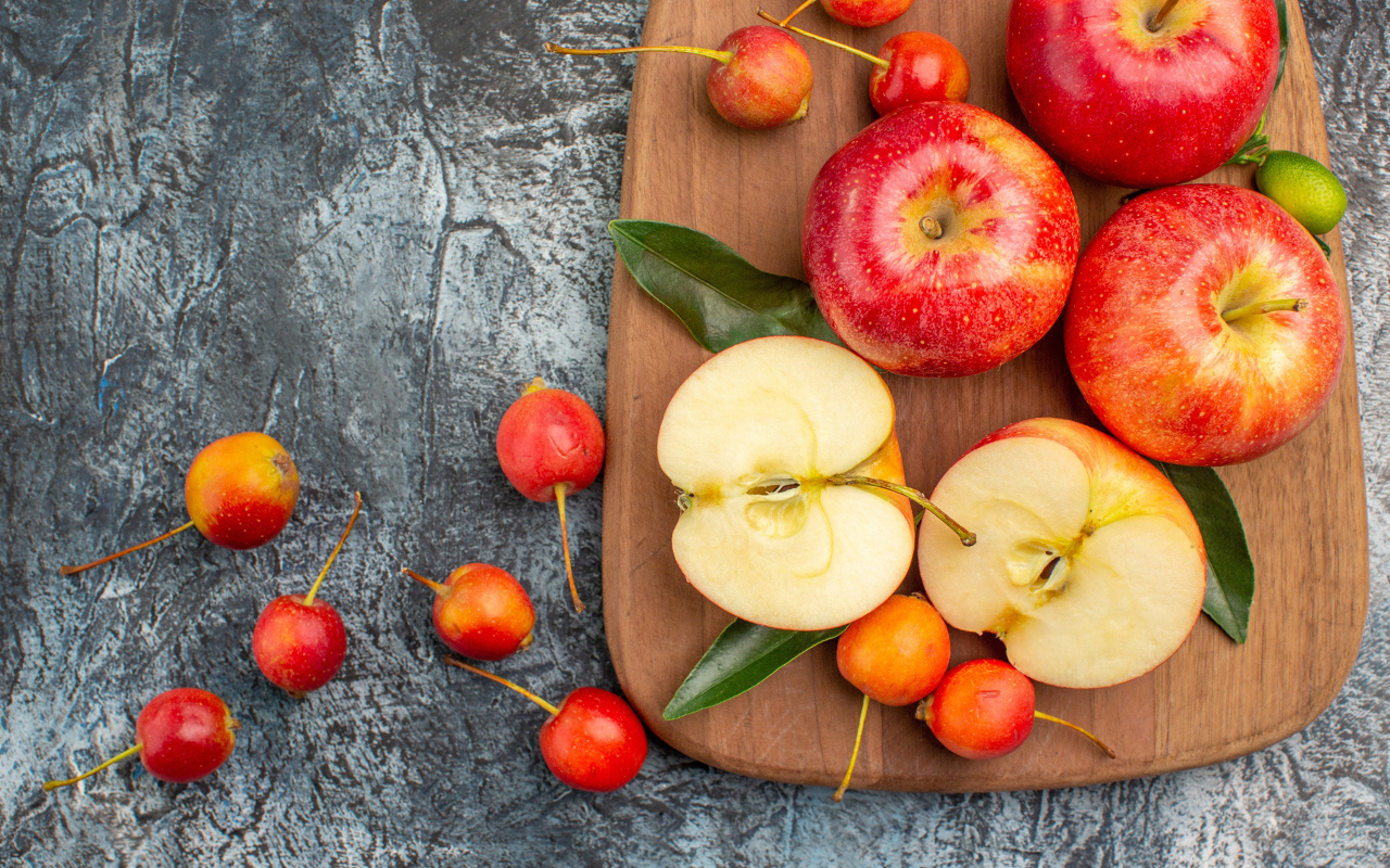 Нарезанные яблоки на деревянной доске на столе