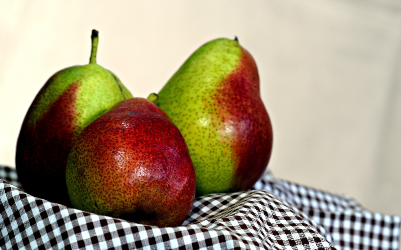 Три груши с полотенцем на столе