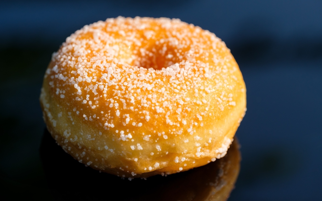 Аппетитный сладкий донат на сером фоне