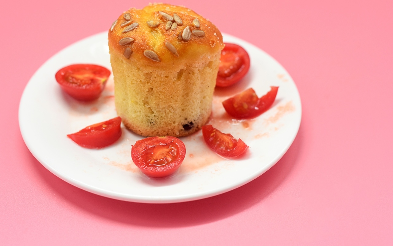 Кекс с помидорами черри на белой тарелке
