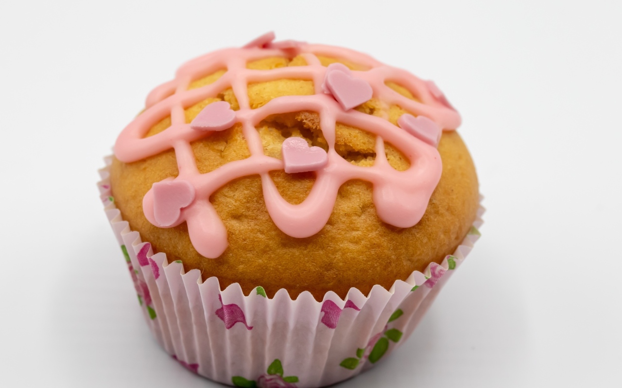 Кекс с клубничной глазурью на сером фоне