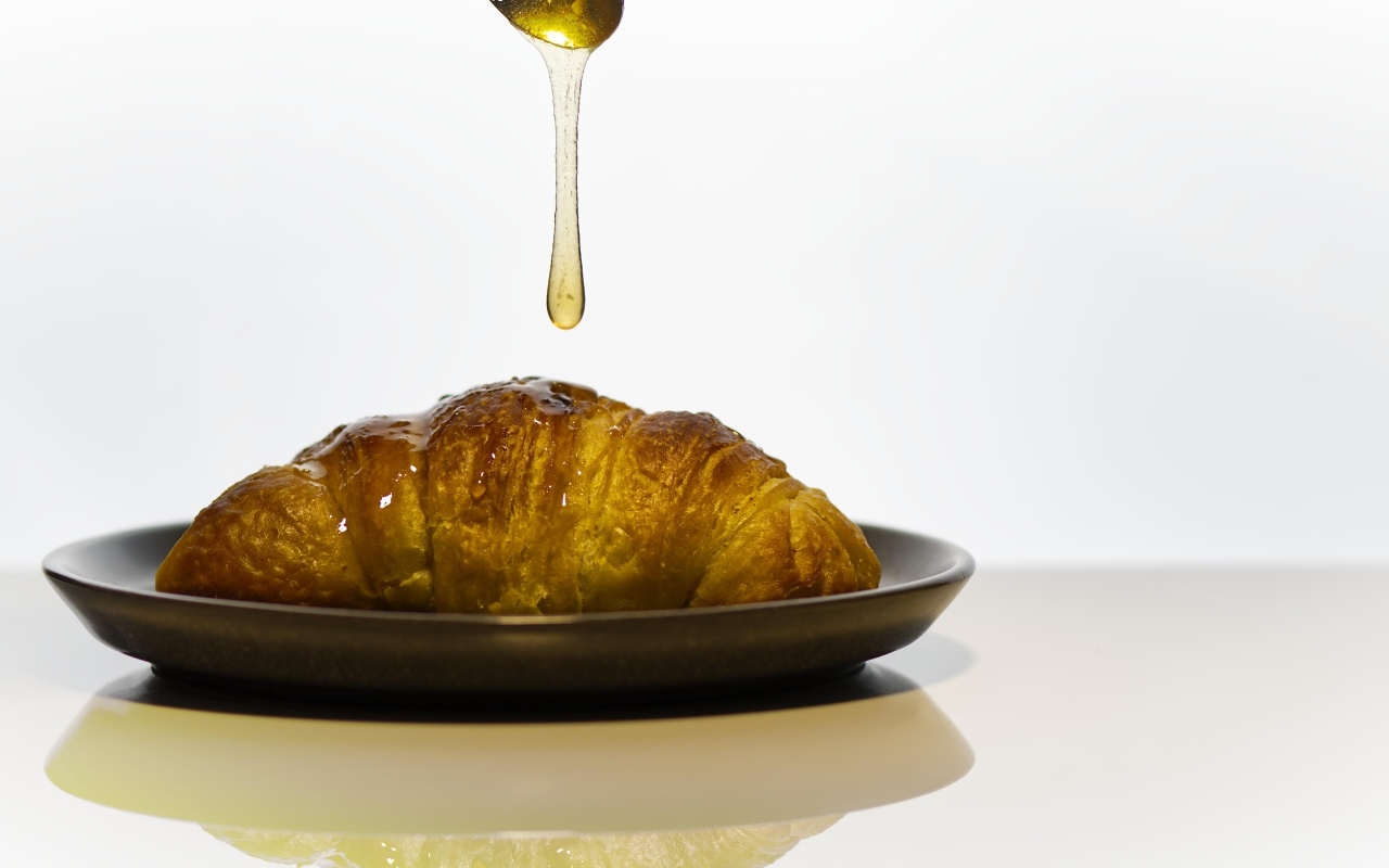 Свежий круассан с медом на завтрак