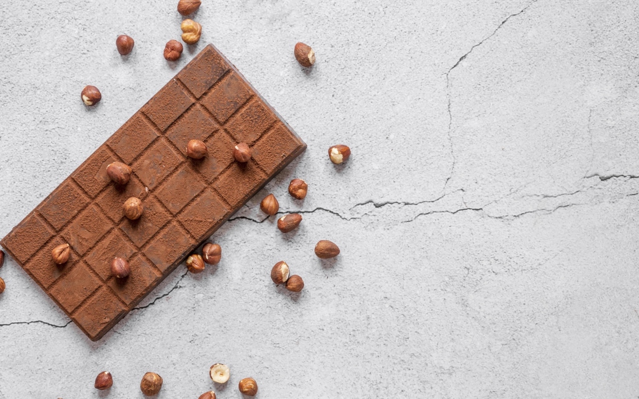 Молочная шоколадка с орехами на сером столе
