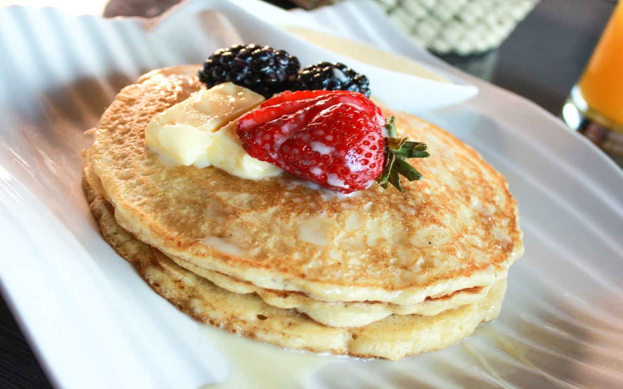 Блины с ягодами на тарелке крупным планом