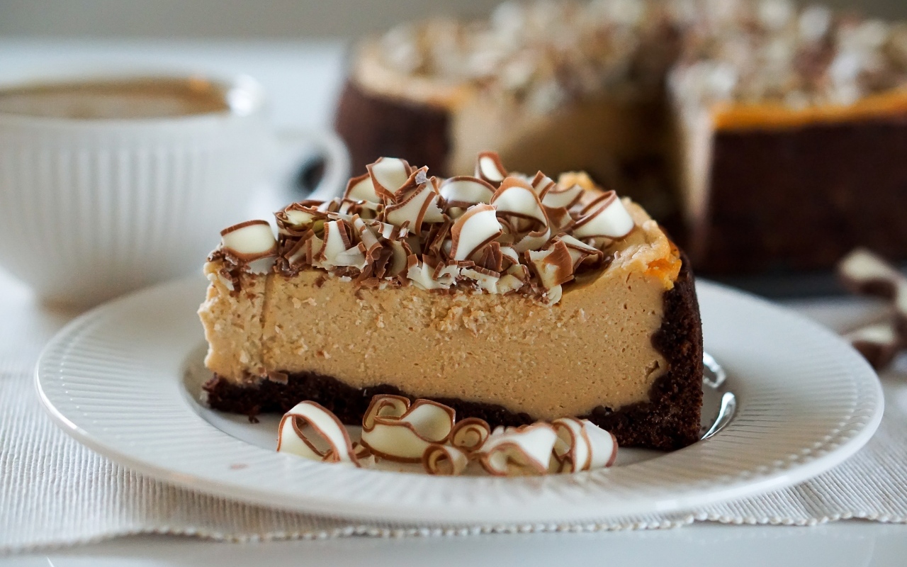 Кусок торта с шоколадной стружкой на белой тарелке