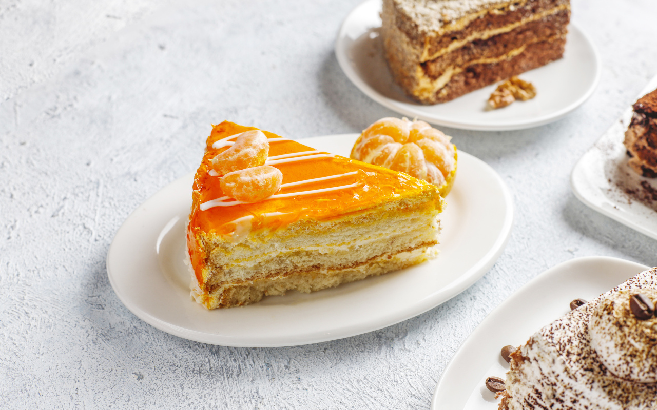 Кусок торта с мандарином на белой тарелке