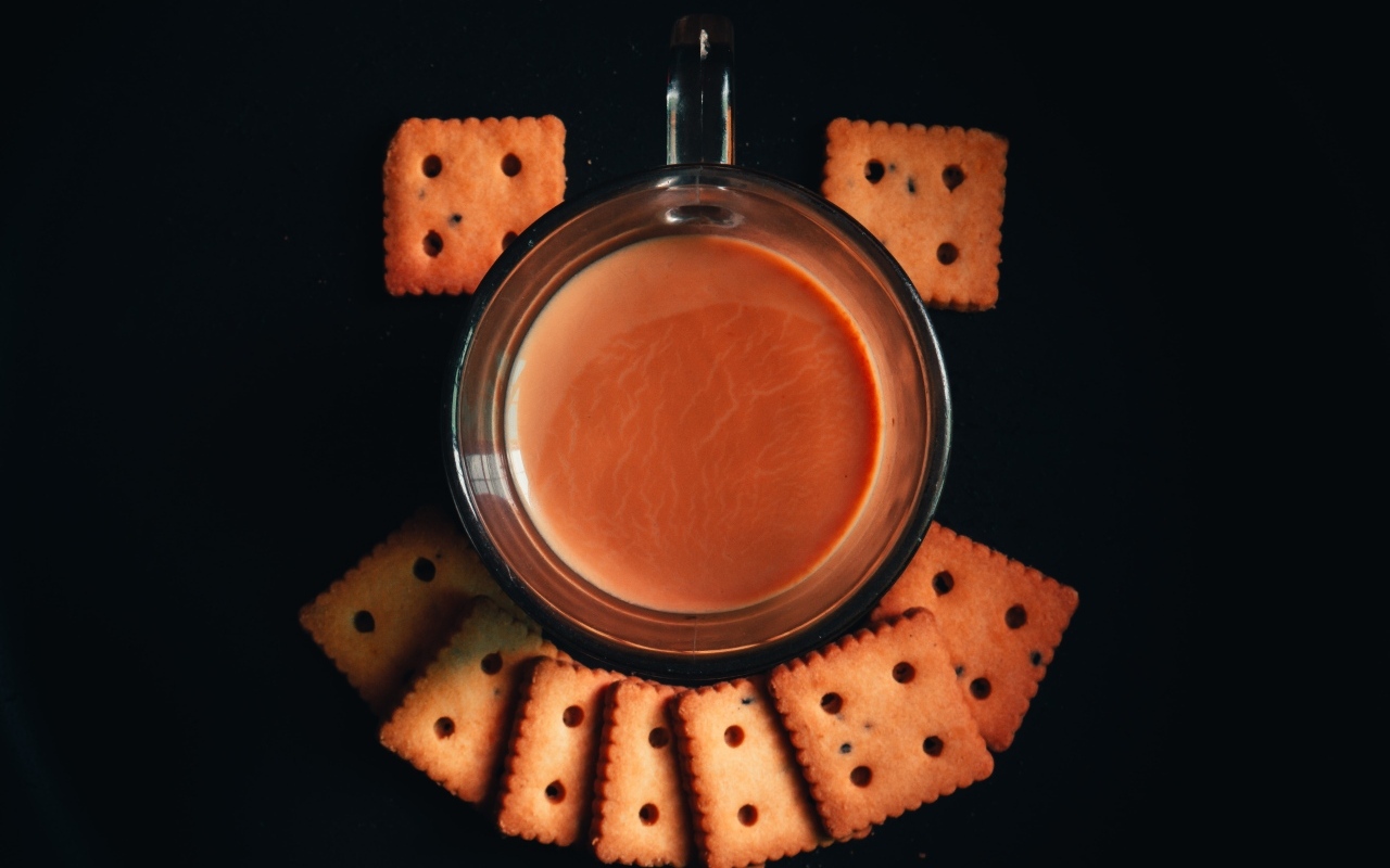 Чашка какао с печеньем на черном фоне