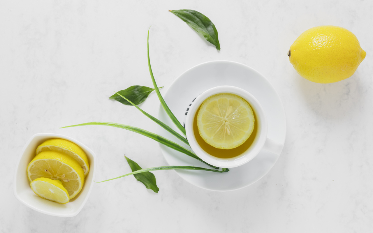 Чай в чашке на столе с кислым лимоном