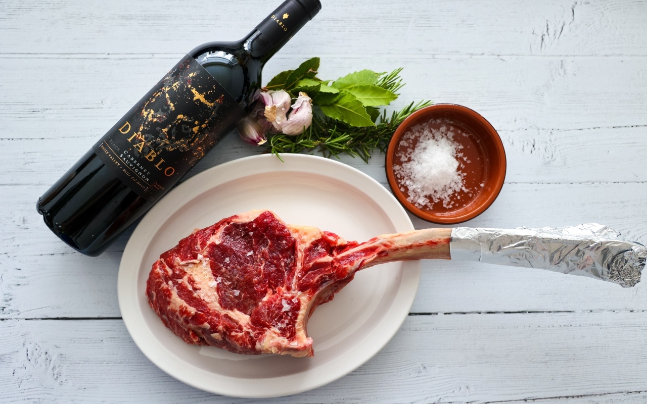 Стейк на кости с бутылкой вина