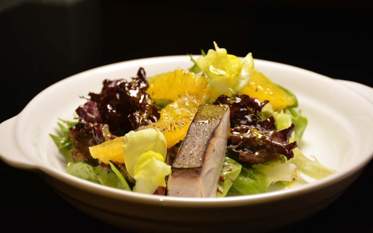 Кусочки рыбы с салатом и лимоном в тарелке