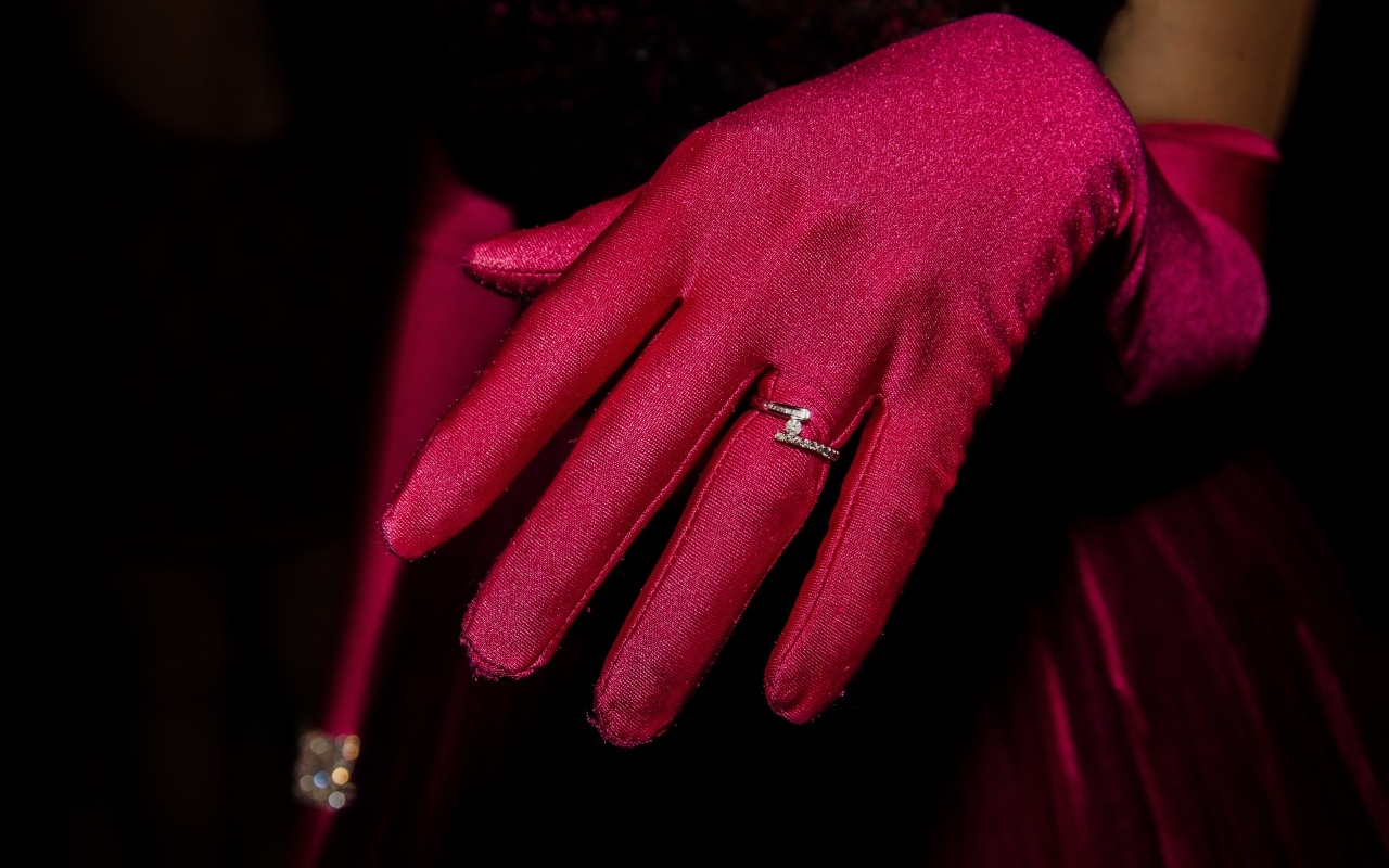 Женская рука с красной перчаткой и кольцом