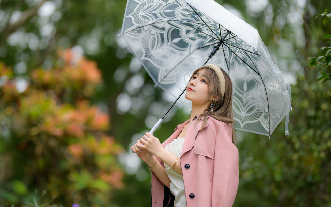 Девушка азиатка в пальто под прозрачным зонтом
