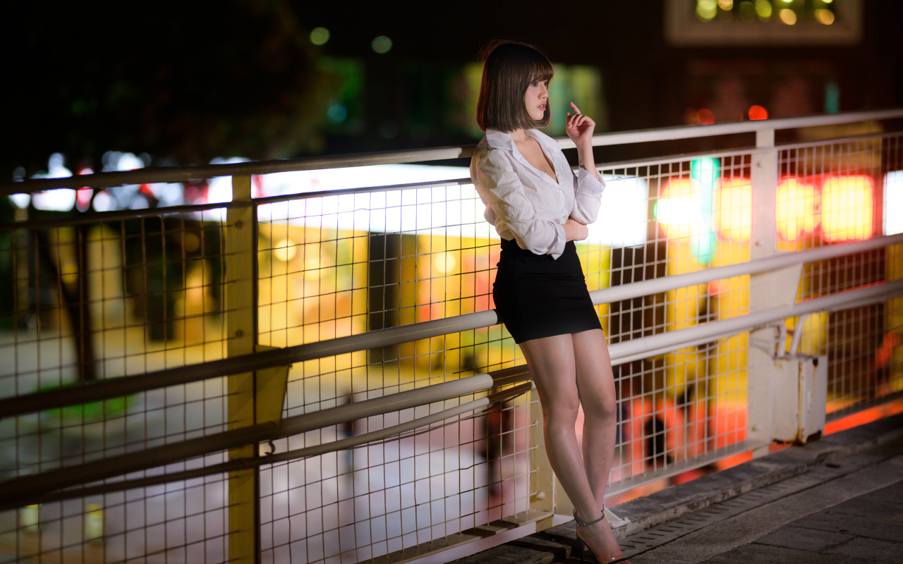 Азиатка в короткой черной юбке позирует для фото