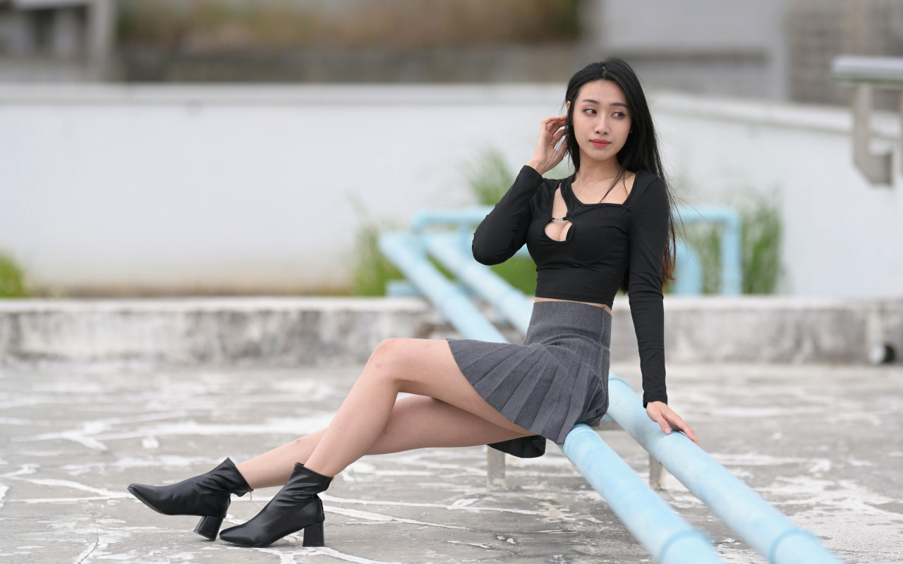 Азиатка в короткой юбке сидит на трубе