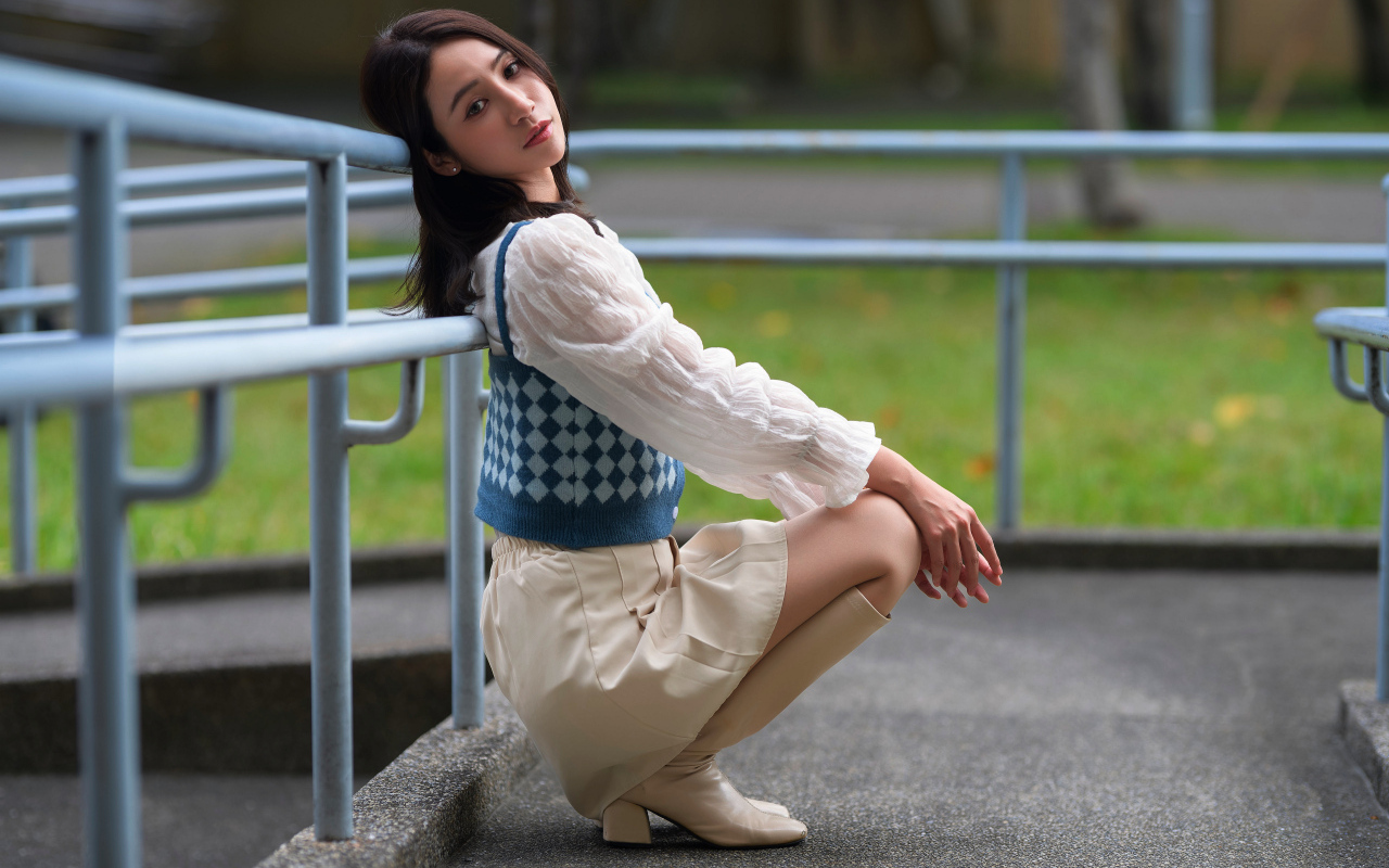 Милая девушка азиатка сидит у перил